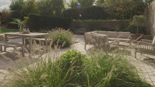 wooden garden furniture collection in a cotswold garden - inviting you to sit down and linger longer in your garden this summer