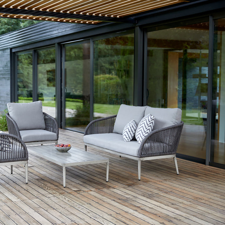 Richmond outdoor sofa set on a wooden deck, featuring a modern rope-woven design, grey cushions, and a sleek aluminium frame for stylish garden lounging.