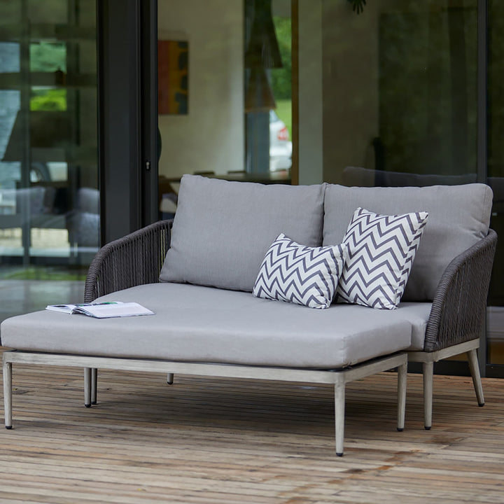Richmond outdoor sofa with thick grey cushions and patterned scatter pillows, offering a stylish and inviting seating option for patios and decking.